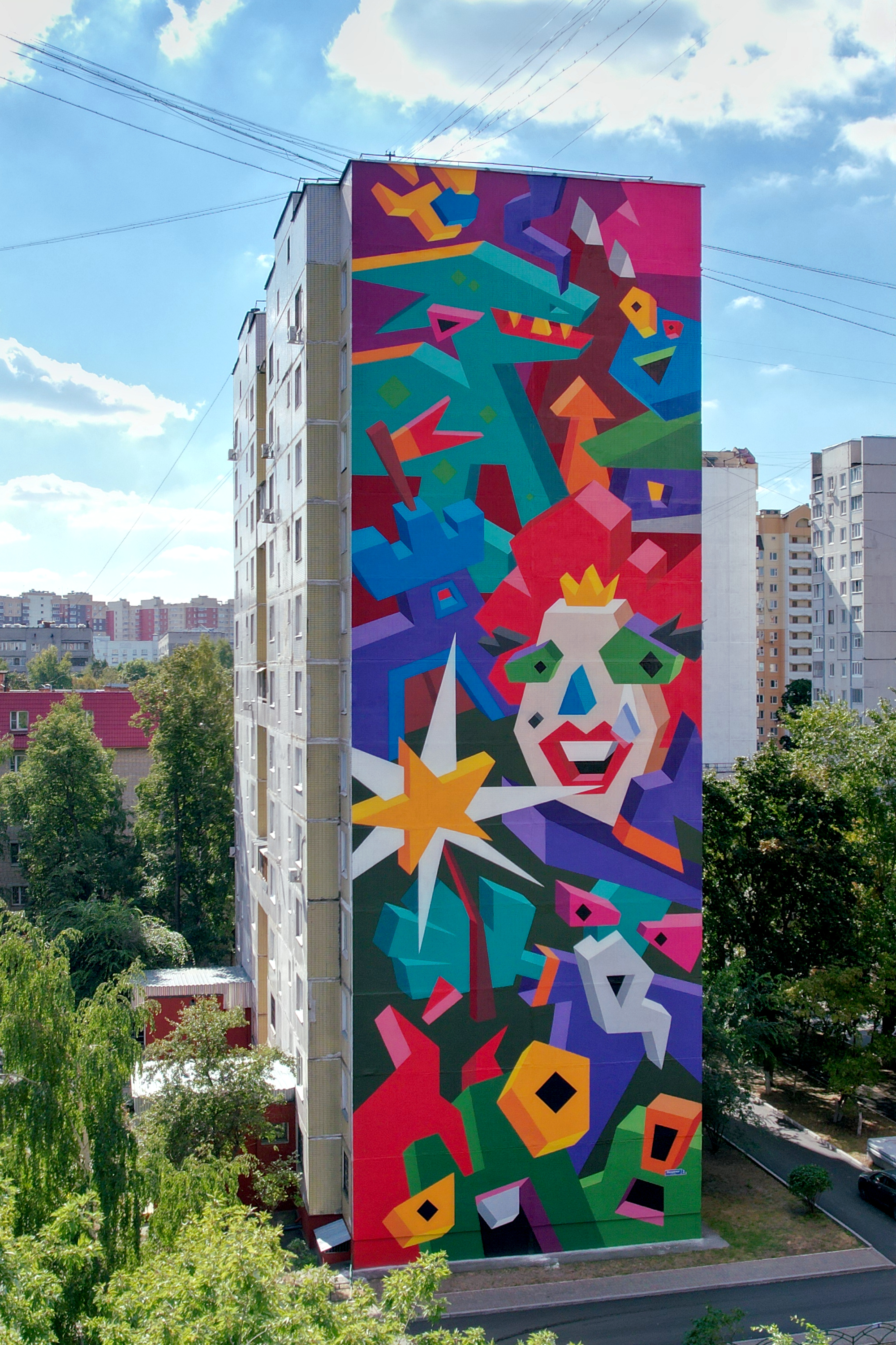 A colorful mural on a 12-story building.