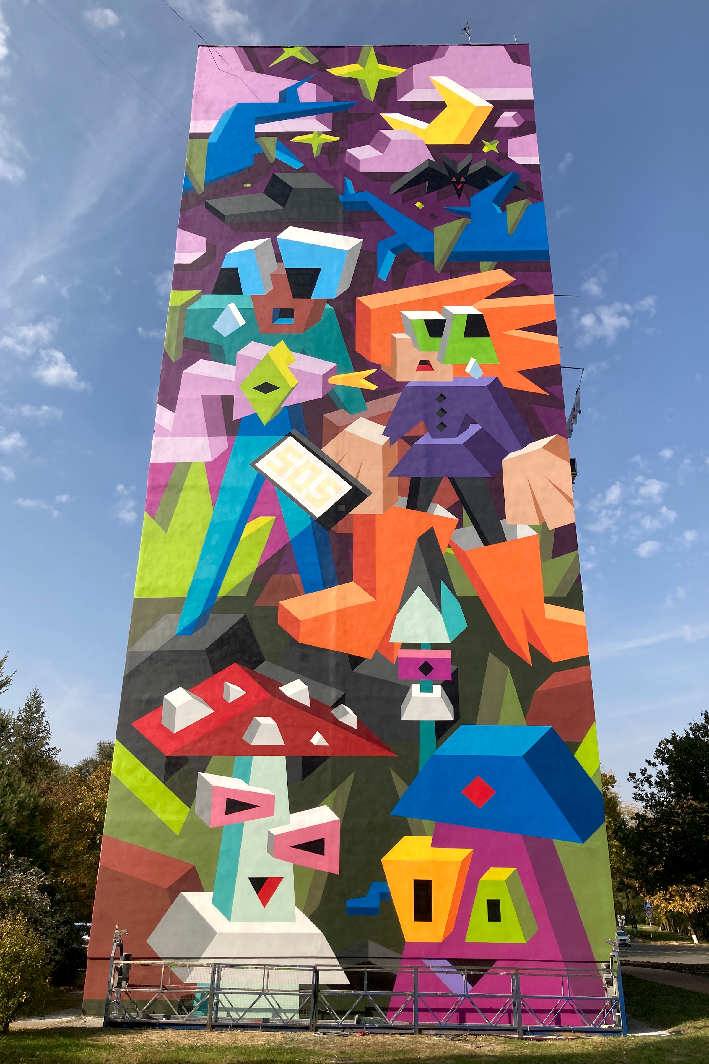 A colorful mural on a 9-story building.